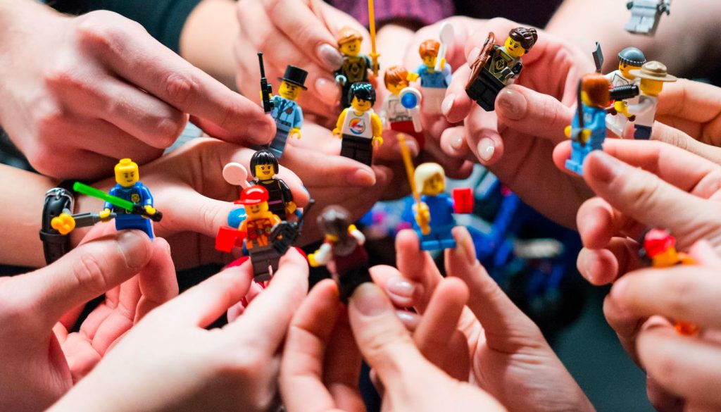 Adults playing with LEGO people pieces